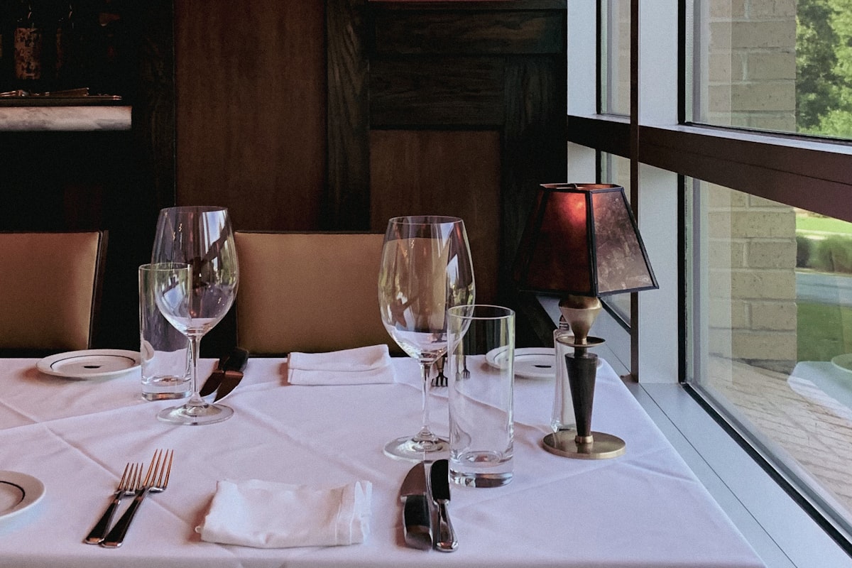 Une table dressée pour deux près d'une fenêtre, où personne n'est encore assis